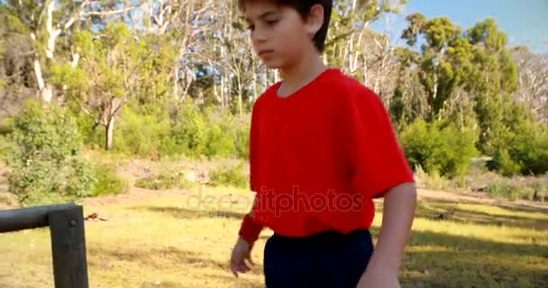 Решительный мальчик идет по препятствию — стоковое видео