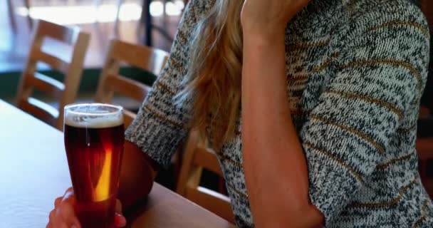 Женщина пьет пиво в баре — стоковое видео