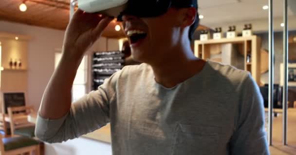 Человек, использующий гарнитуру виртуальной реальности в ресторане — стоковое видео