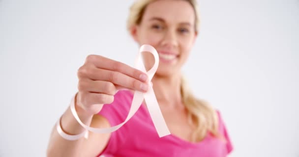 Smiling woman showing breast cancer awareness ribbon — Stock Video