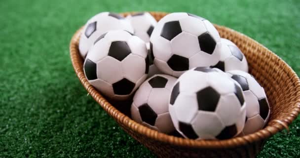 Bolas de futebol em cesta de vime na grama artificial — Vídeo de Stock