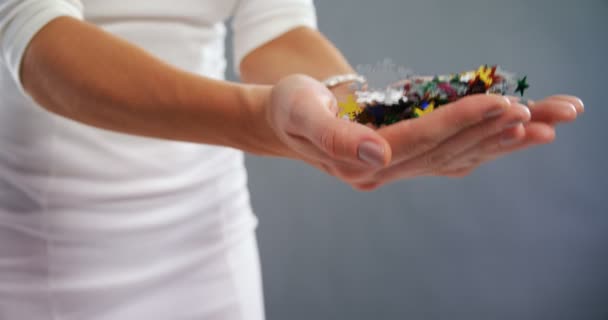 Sección media de la mujer jugando con confeti — Vídeo de stock