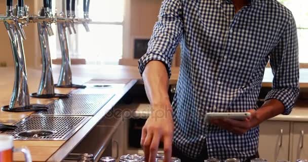 Bar tender avec tablette numérique au comptoir — Video