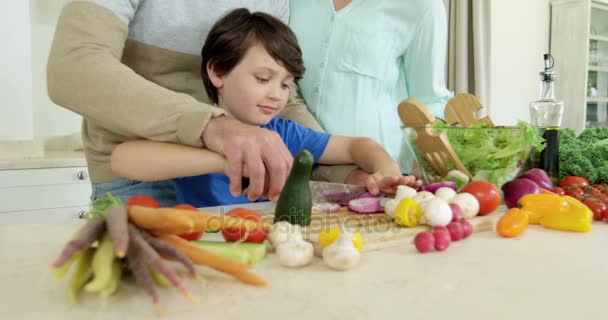 Ouders bijstaan van zoon in hakken plantaardige — Stockvideo