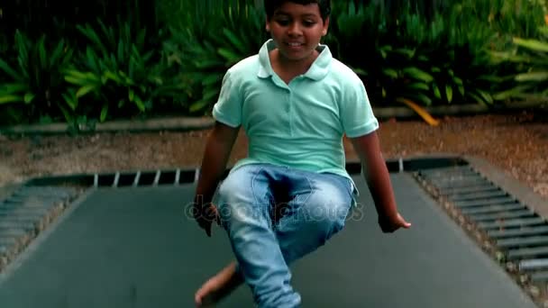 Хлопчик стрибає вгору і вниз на батуті — стокове відео