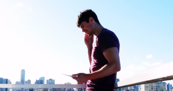 Человек держит цифровой планшет на балконе — стоковое видео