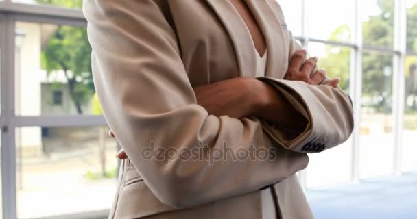 Бізнес-леді, що стоїть з обіймами, схрещеними в офісі — стокове відео