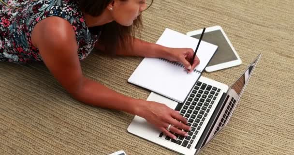 Executivo usando laptop enquanto escreve no diário — Vídeo de Stock