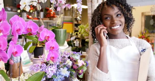 Floristería femenina hablando por teléfono móvil — Vídeo de stock