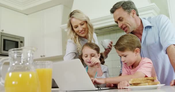 Família usando laptop juntos na cozinha — Vídeo de Stock