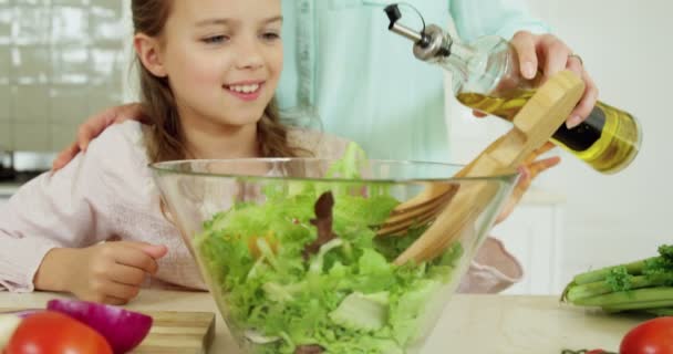 Mutter hilft Tochter bei der Zubereitung von Salat — Stockvideo