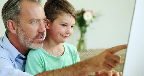 Familie en zoon samen gebruiken van de computer in de woonkamer — Stockvideo