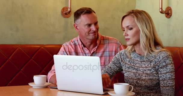 Couple utilisant un ordinateur portable tout en prenant un café — Video