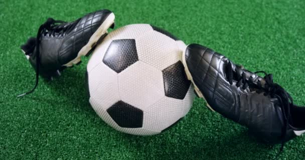 Football and cleats on artificial grass — Stock Video