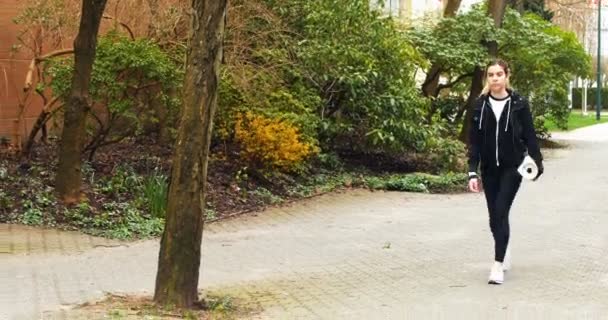 Mujer caminando con colchoneta de ejercicio en el parque — Vídeo de stock