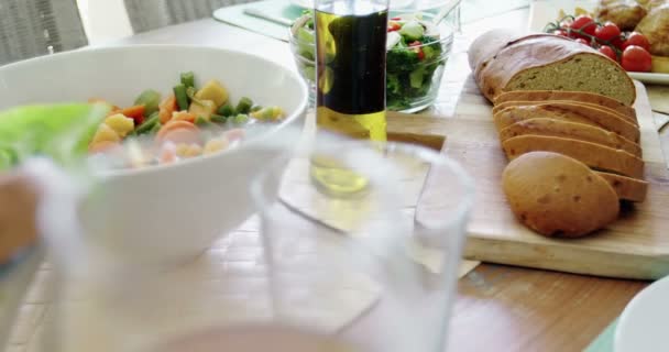 Чаша салата, оливковое масло и ломтики хлеба на столе — стоковое видео