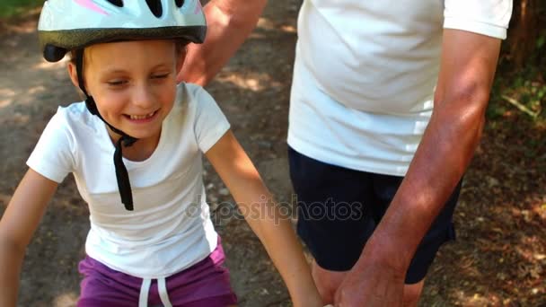 Grootvader onderwijs zijn kleindochter een fiets te rijden — Stockvideo
