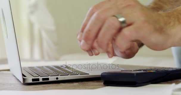 Homem usando laptop para calcular conta — Vídeo de Stock