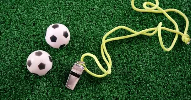 Footballs and referee whistle on artificial grass — Stock Video