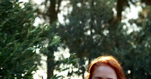 Mujer sonriente de pie en una granja de olivos en un día soleado — Vídeo de stock