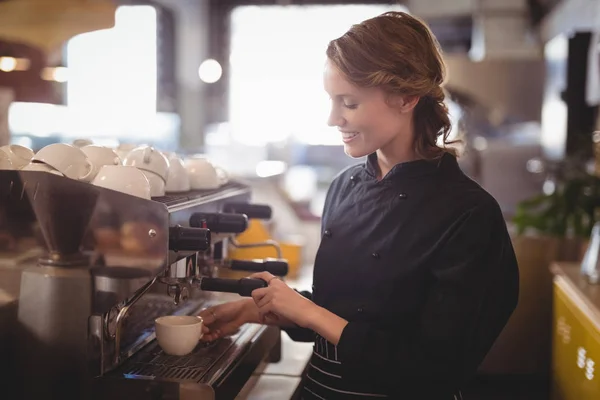 Молодая официантка использует кофеварку — стоковое фото