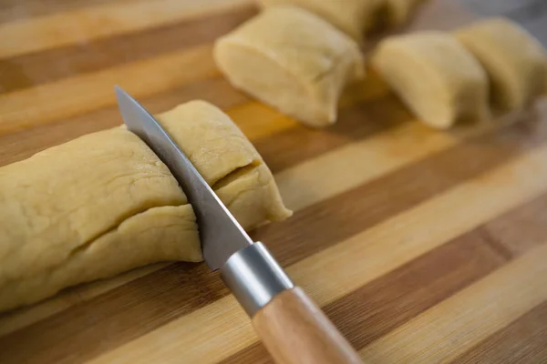 Kitchen knife cutting dough — Stock Photo, Image