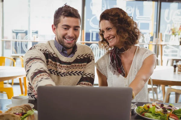 Homem com mulher usando laptop no café — Fotografia de Stock