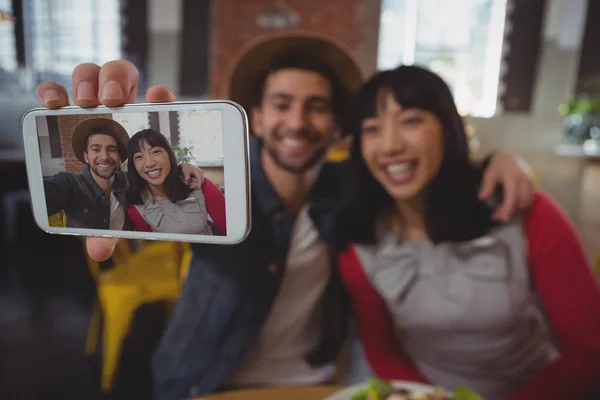 Homem com mulher tomando selfie no café — Fotografia de Stock