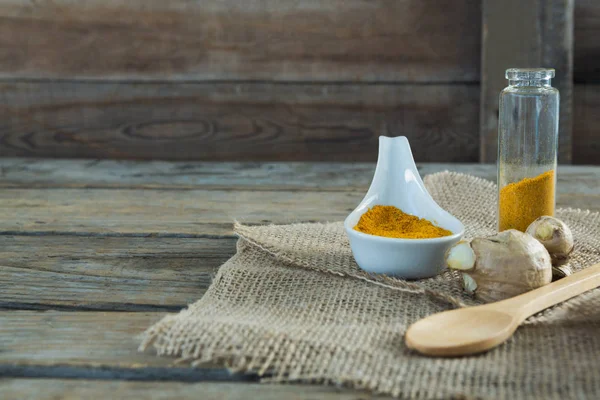 Turmeric powder and ginger on sack — Stock Photo, Image