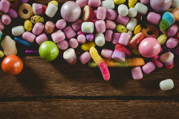 Närbild av olika godis på träbord — Stockfoto