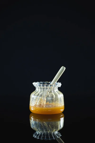 Honey dipper in glazen pot — Stockfoto