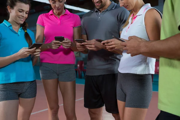 Jugadores de voleibol usando teléfonos — Foto de Stock