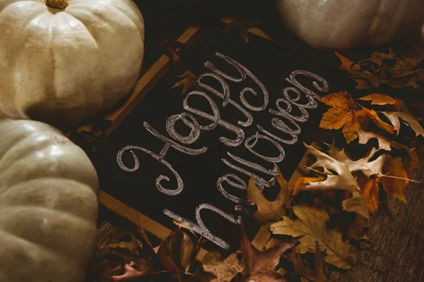 Перегляд щасливого тексту Хеллоуїна на шифері з гарбузами та осіннім листям — стокове фото