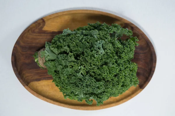 Col rizada fresca en plato de madera — Foto de Stock