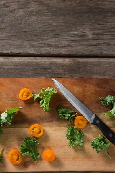 Vue aérienne des tranches de chou frisé et de tomate sur la planche à découper — Photo