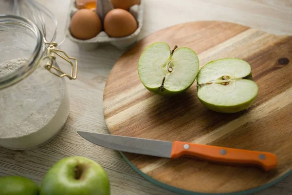 Granny smith apple halved on cutting board — Stock Photo, Image
