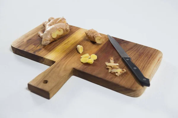 Coltello e zenzero fresco sul tagliere in legno — Foto Stock