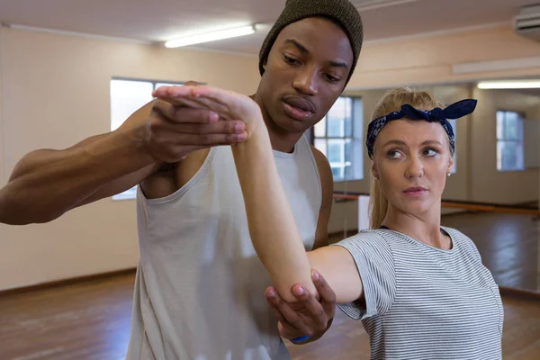 Uomo che assiste un'amica donna nella danza — Foto Stock