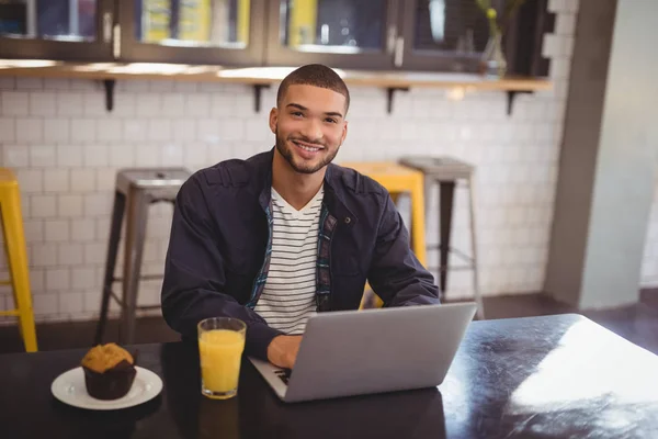 Mężczyzna siedzący z laptopa w coffee shop — Zdjęcie stockowe