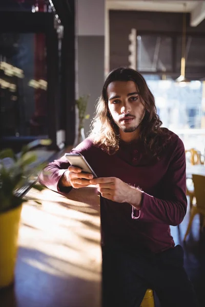 Homem com cabelos longos usando smartphone — Fotografia de Stock