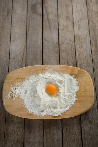 Egg yolk in flour on cutting board — Stock Photo, Image