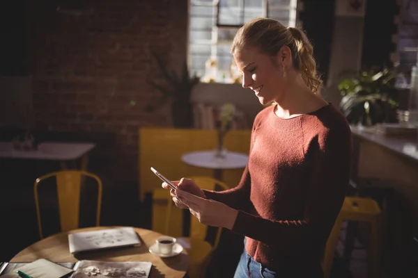 Mujer usando teléfono inteligente en la cafetería —  Fotos de Stock