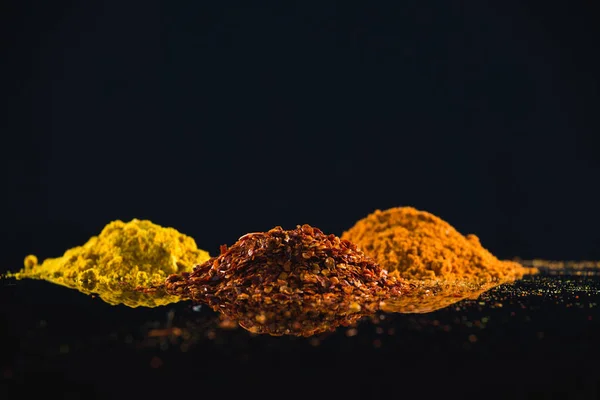 Pulveriserad Kryddor mot svart bakgrund — Stockfoto