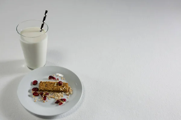 Müsli bar och mjölk på vit bakgrund — Stockfoto