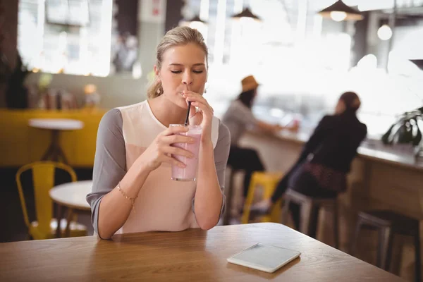 Mujer bebiendo batido en la cafetería —  Fotos de Stock