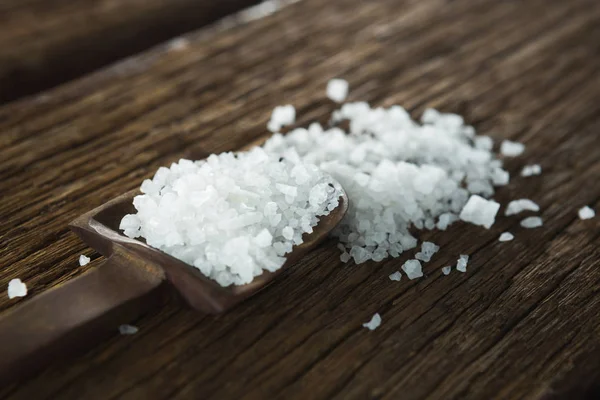 Αλάτι στο κουτάλι στο ξύλινο τραπέζι — Φωτογραφία Αρχείου