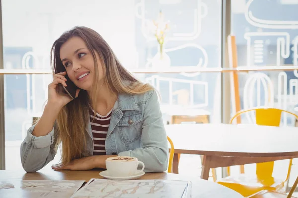 Молода жінка розмовляє по телефону в кафе — стокове фото