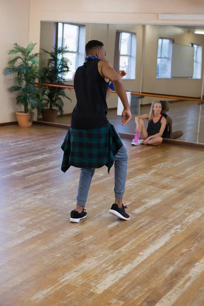 Bailarín masculino ensayando con un amigo sentado — Foto de Stock