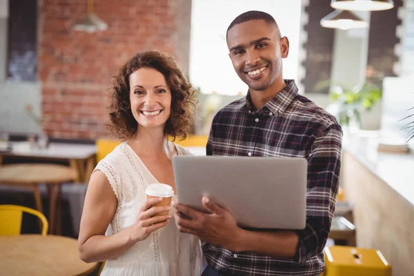 Amigos com copo de café descartável e laptop — Fotografia de Stock