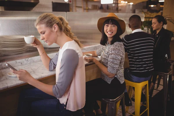 Femme assise au milieu d'amis au comptoir — Photo